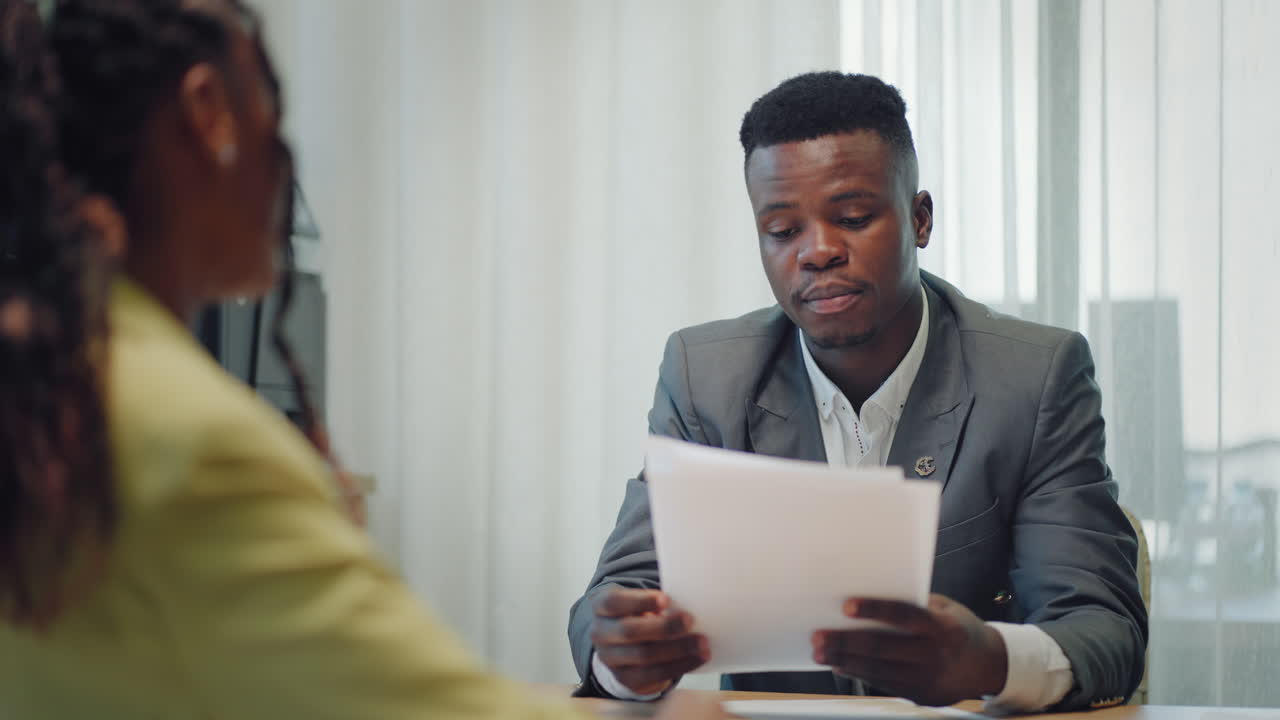 Happy confident black woman recruit handshaking employer getting hired at new job. Smiling young female professional manager shake hand of black man client or customer making business office meeting