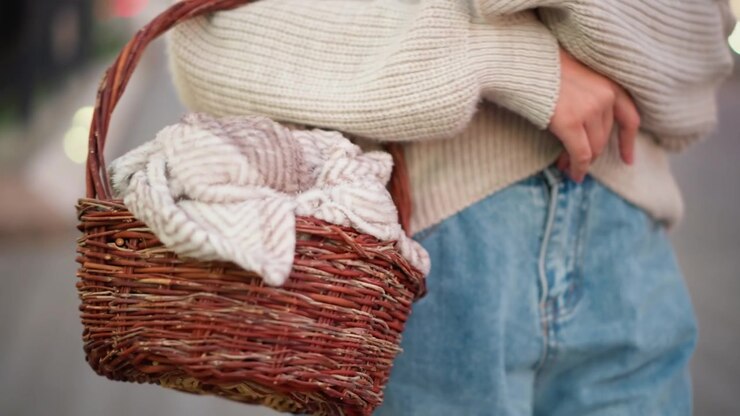 Donna che trasporta un cesto di vimini con coperta all'aperto