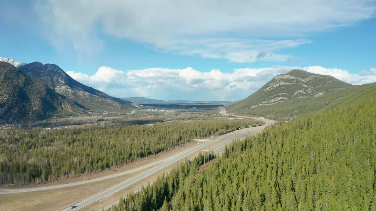 vista aérea de drones volando hacia atrás desde la carretera a través de las montañas oscureciendo la vista detrás del bosque