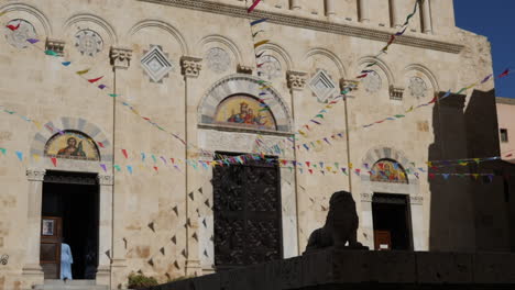 monja entrando a una iglesia bajo cuerdas de banderas coloridas