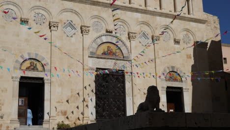 nun entering a church under strings of colorful flags