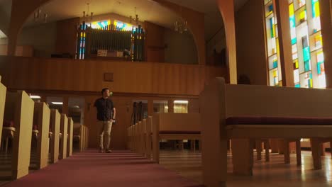 Wide-shot-ethnic-male-walking-down-a-church-aisle-in-a-sanctuary