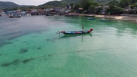 volando alrededor de un bote de cola larga en medio del fondo de la isla de agua