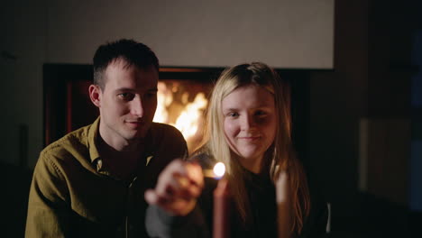 couple by the fireplace lighting candles