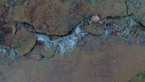 toma estática de escena meditativa, agua que fluye sobre hermosas rocas coloridas en cedar creek en monterey kentucky