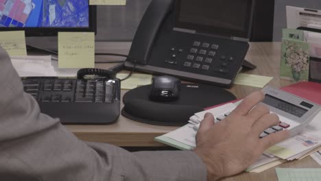 office worker using a calculator to make calculations