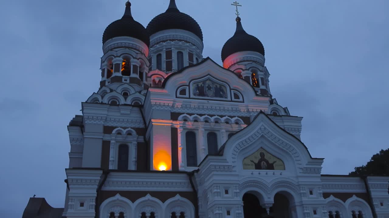 Religious church or building called St Alexander Nevsky cathedral in the middle on Tallinn oldtown at Toompea during night time. Churches are on top of the tips of the towers and cinematically lit.
