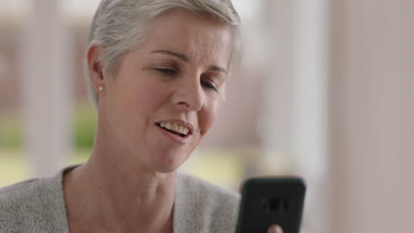 Mujer-Madura-Feliz-Teniendo-Video-Chat-Usando-Una-Abuela-De-Teléfono-Inteligente-Disfrutando-De-Una-Conversación-Con-Una-Familia-Que-Comparte-El-Estilo-De-Vida-Charlando-Por-Teléfono-Móvil-Con-Sus-Nietos-Relajándose-En-Casa-4k