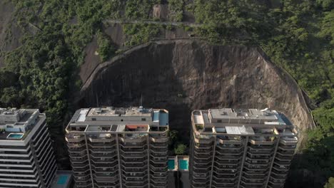 Vista-Aérea-De-Retroceso-Lento-De-Condominios-Residenciales-De-Gran-Altura-Que-Residen-En-La-Ladera-De-La-Montaña-Parcialmente-Cortada-Que-Revela-Toda-La-Montaña-Detrás