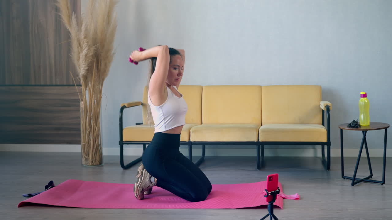 mujer haciendo un entrenamiento en casa con pesas