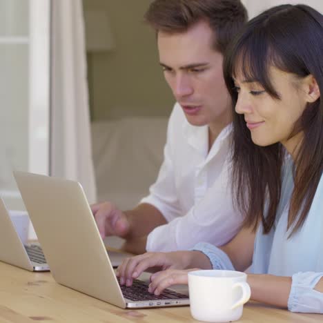 couple working on laptop computers together