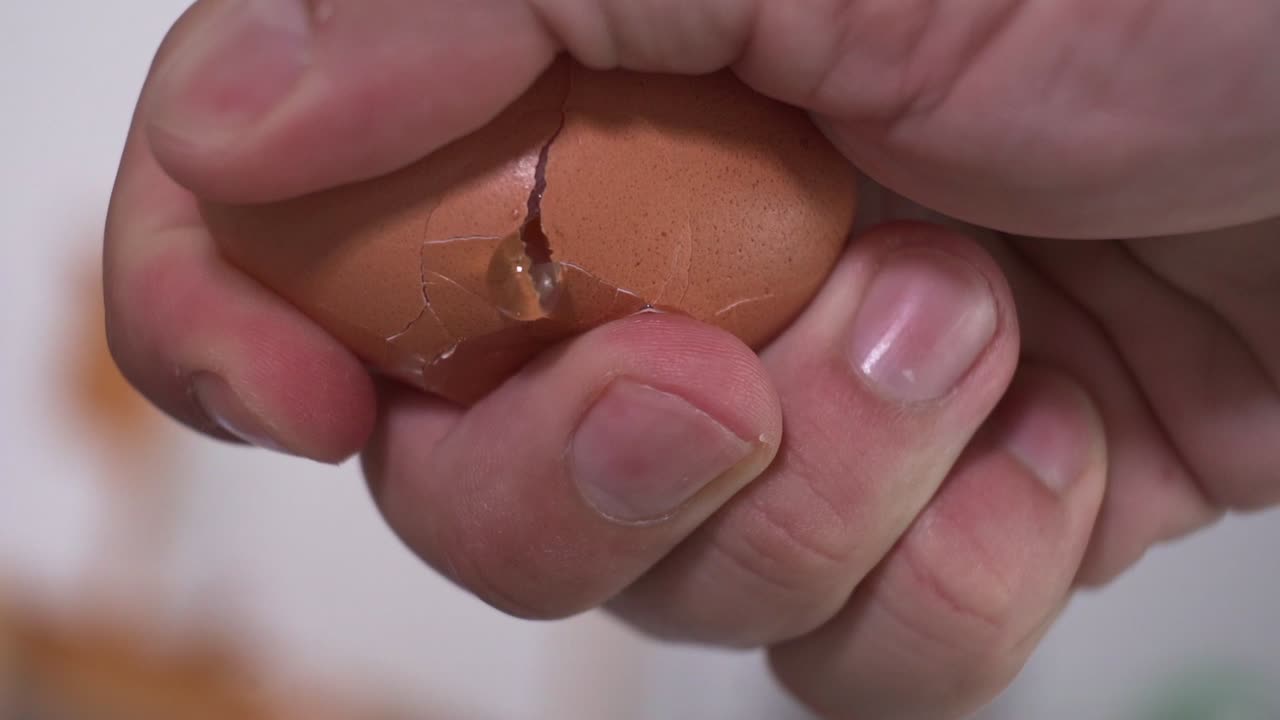 slow motion failing to crack open an egg open, messy breaking egg, close up at 120fps HD footage