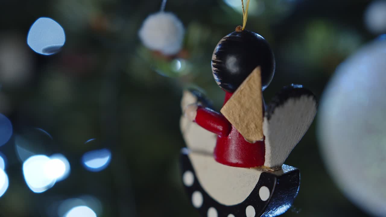 Vintage wooden Christmas tree ornament of a cheerful little man hangs among festive decorations