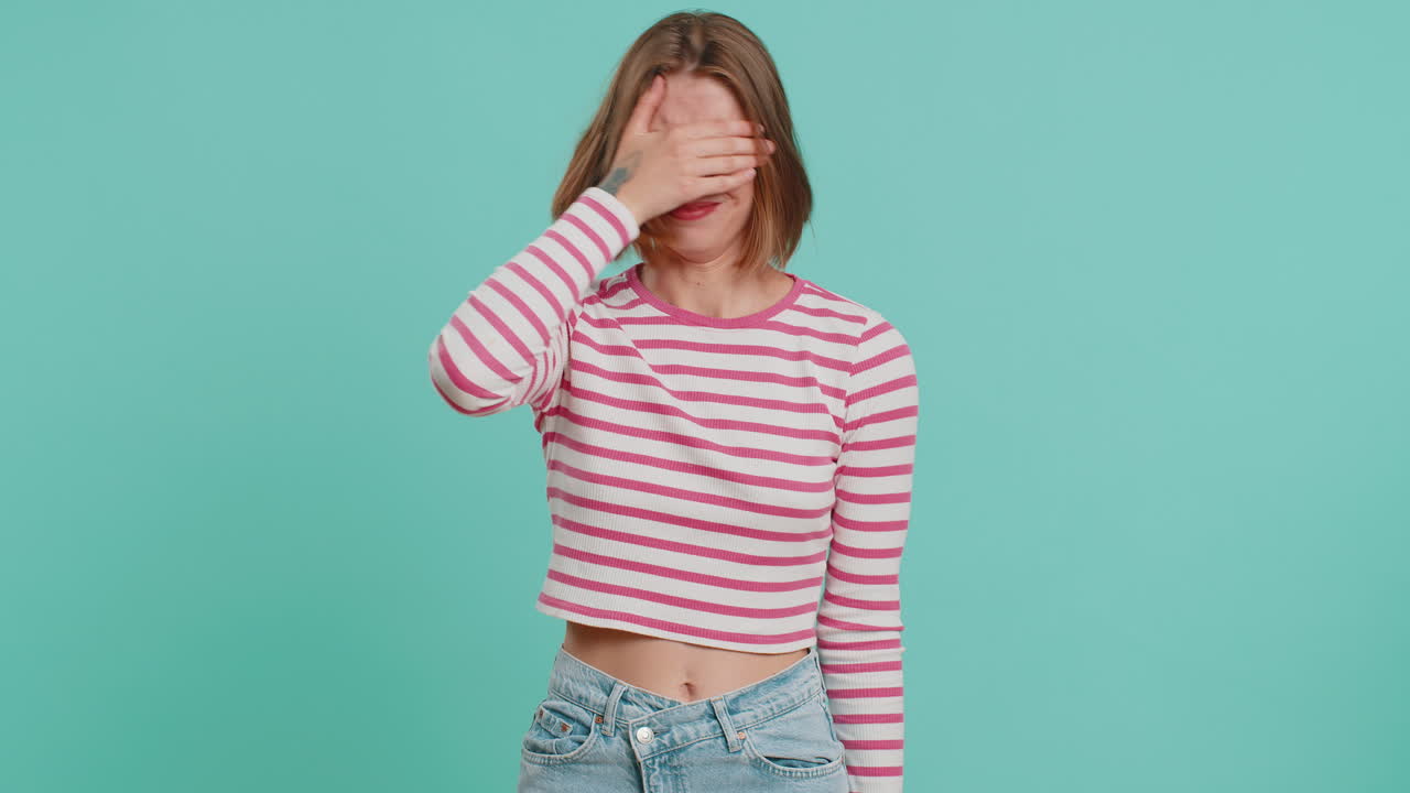 Afraid young woman closing eyes with hand showing stop gesture confused shy scared to watch awful