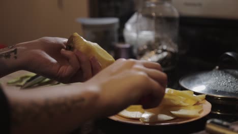 a woman cutting off ripe mango and placing it on a plate - close up shot