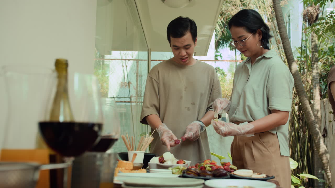 Asian Couple Skewing Meat and Vegetables Outdoors