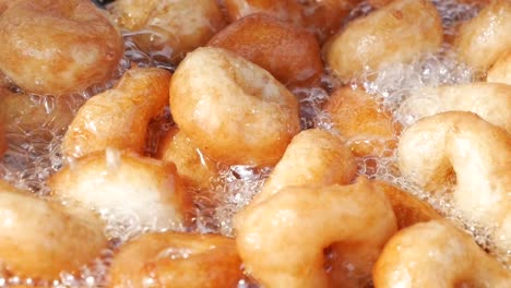 close-up of doughnuts frying in oil