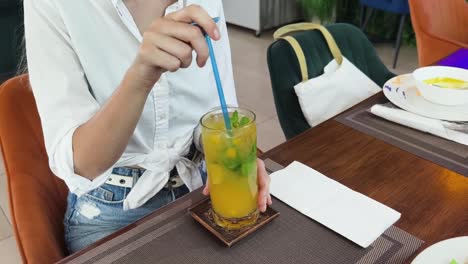 woman drinking iced drink at a cafe