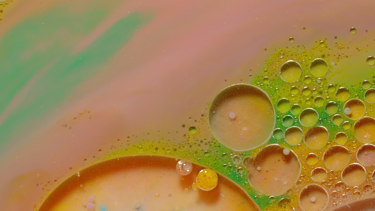 burbujas de tinta mezcladas con sustancia líquida de aceite, leche, jabón, pintura acrílica brillante en una superficie colorida