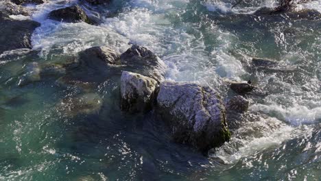 rushing river rapids breaking over boulders in the river leno as it flows through rovereto in the italian alps