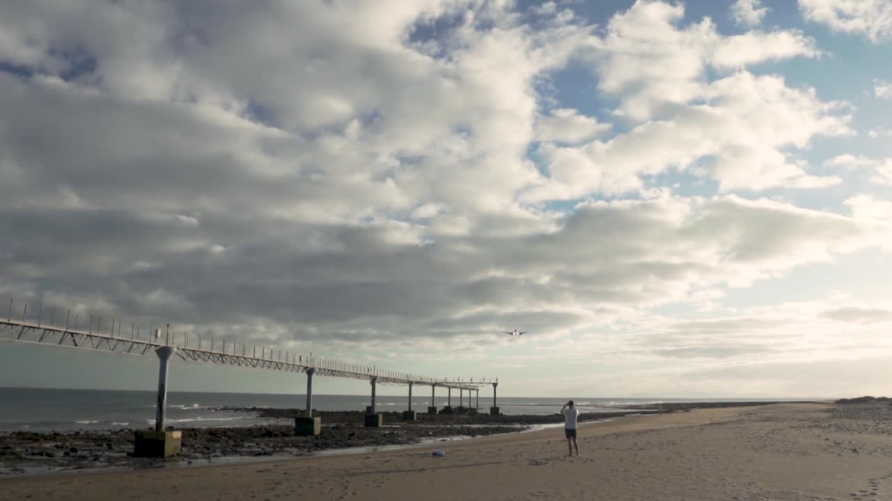 해변 에 착륙 하는 비행기 의 사진 을 찍는 사람