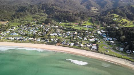 Vista-Aérea-De-La-Pequeña-Ciudad-De-Surf-En-La-Isla-Norte-De-Nueva-Zelanda