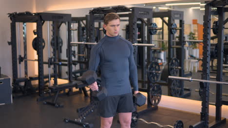 Determined-Motivated-Sporty-Fit-Attractive-Slavic-Man-Practicing-Weight-Training-Performing-Dumbbell-Bicep-Curls-Workout-Exercising-in-Modern-Gym