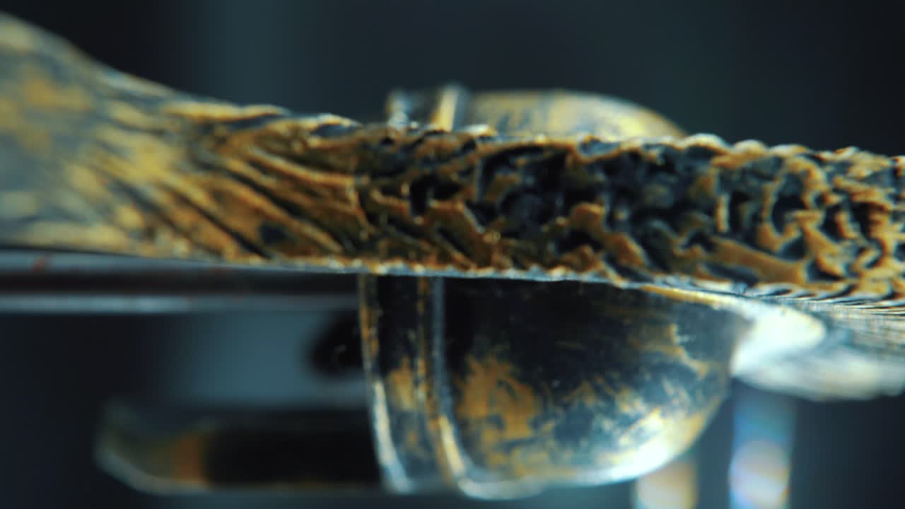 una toma cinematográfica macro vertical de un diseño de rostro espartano, casco de bronce de metal guerrero, en un soporte giratorio, iluminación de estudio, movimiento lento de 4k