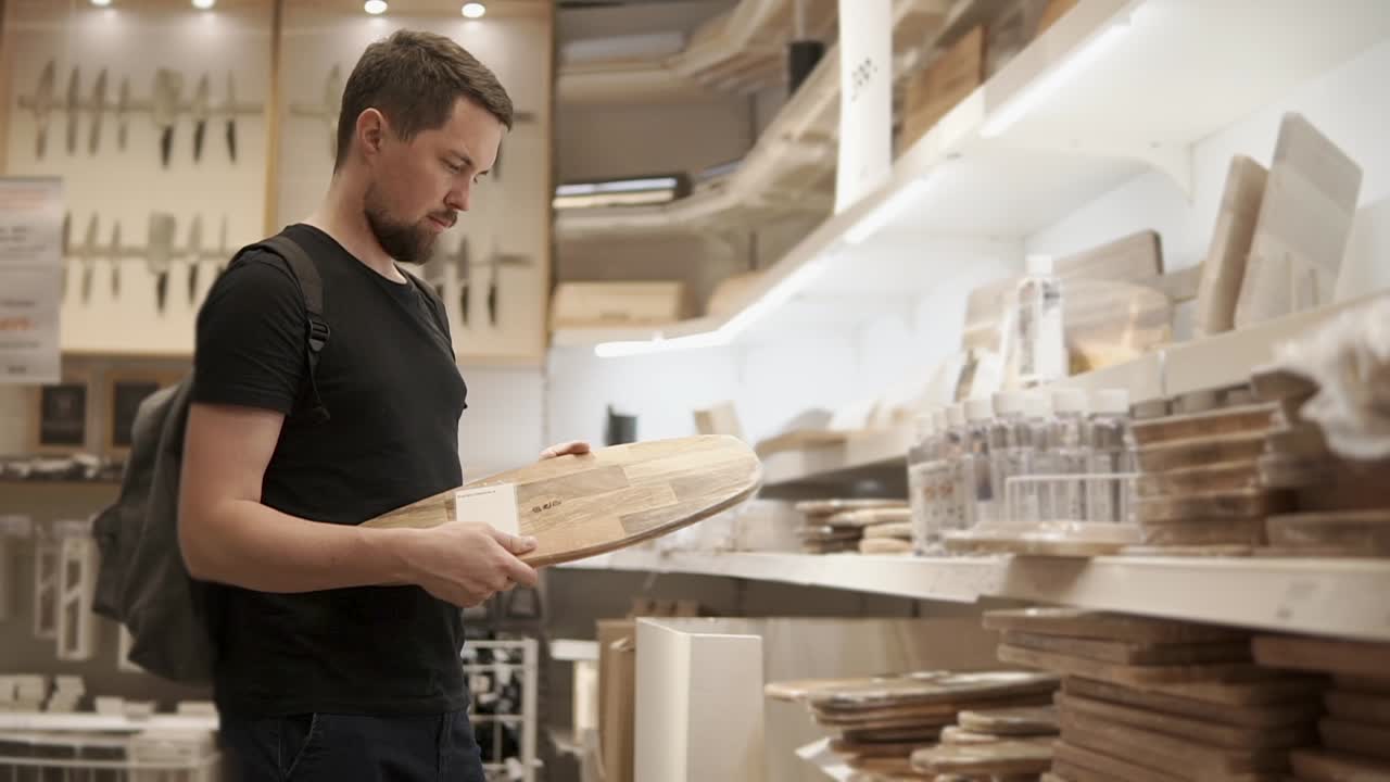 hombre comprando tablas de cortar en una tienda de muebles