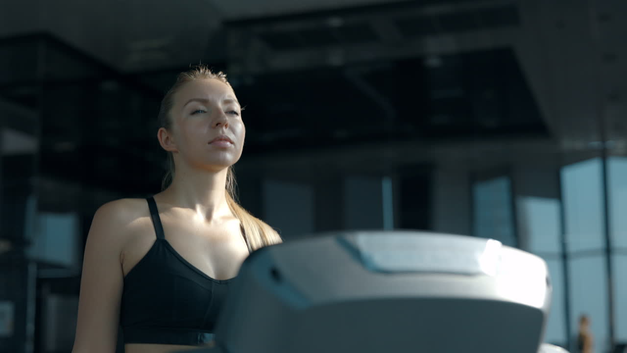 Woman exercising on a treadmill in a modern gym