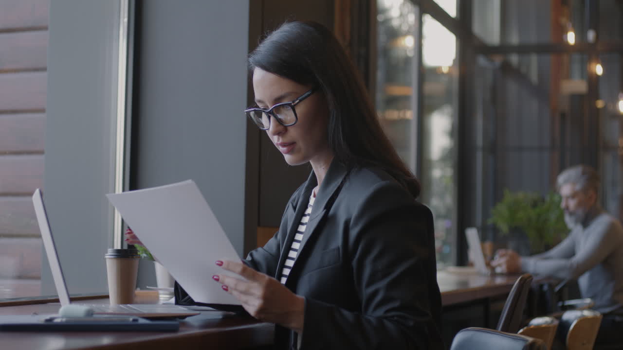 Woman Working on Documents in a Coffee Shop
