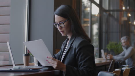 woman working on documents in a coffee shop
