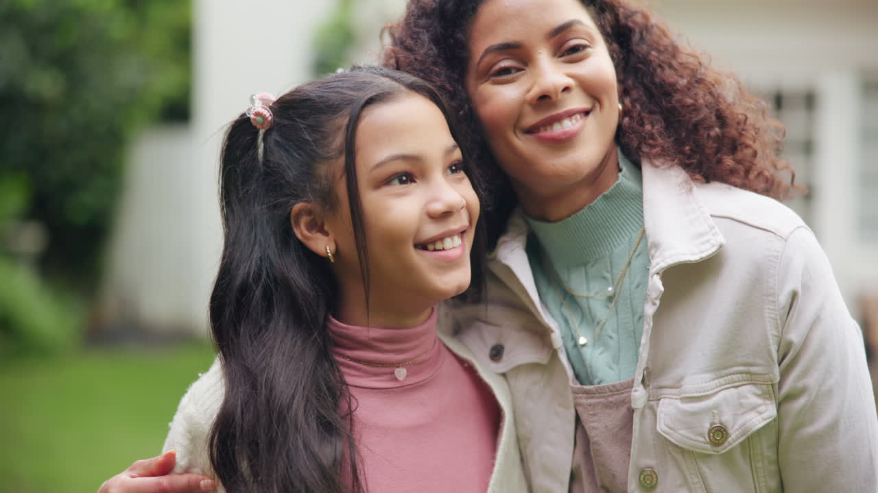 A mother and daughter embrace outdoors
