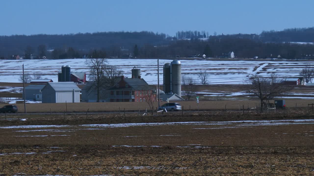 시골 펜실베이니아의 도로를 따라 아미쉬 마차가 여행합니다.