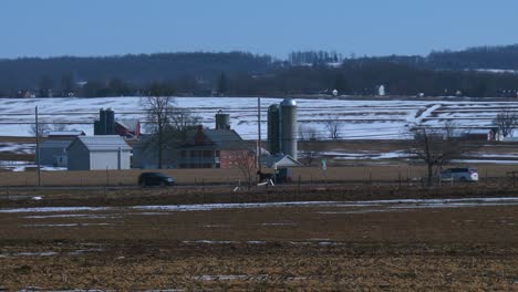 Un-Carro-De-Caballos-Amish-Viaja-A-Lo-Largo-De-Una-Carretera-En-La-Zona-Rural-De-Pennsylvania