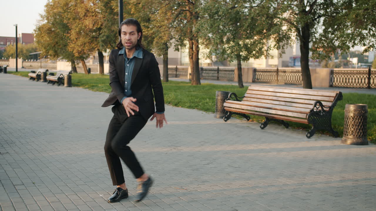 Man in a black suit walking in a park