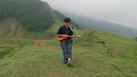 musician playing the ukulele and singing in a mist covered landscape