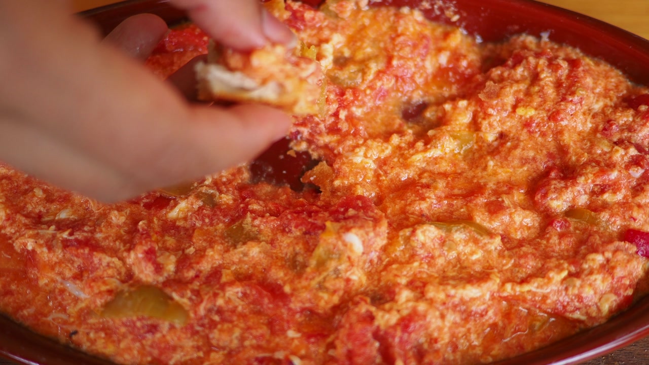 Hand Dipping Bread into a Delicious Menemen Dish