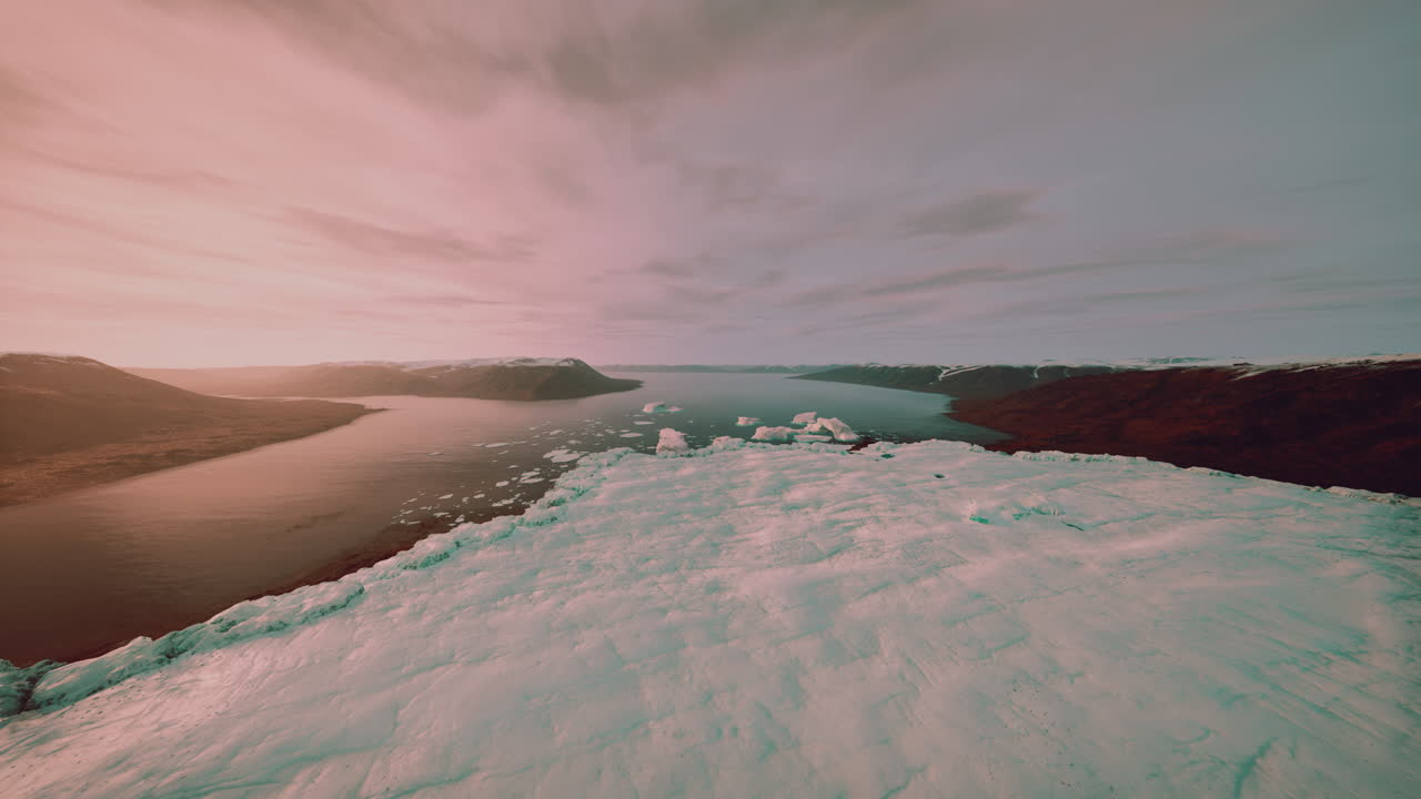 Distant shoreline scene featuring melting snow and ice beneath gentle pastel sky