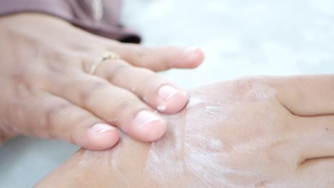 woman applying moisturizer to her hands