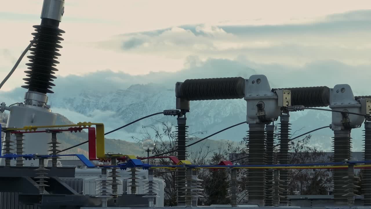 High voltage lines with snowy mountains in the background, serene mood