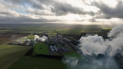 vista de pájaro: en el corazón de las tierras de cultivo, el gigante industrial hums, su chimenea
