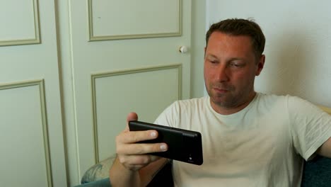 man watching tv on his phone