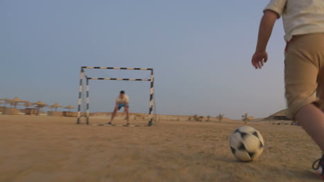 boy is ready to make a goal in this beach football