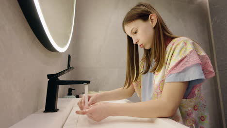 girl washing hands in bathroom