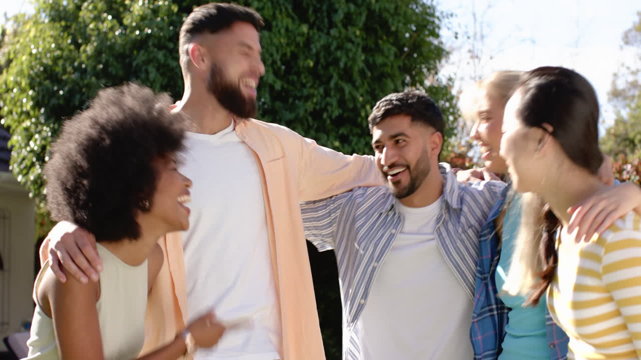 Group of young friends laughing and hugging outdoors, enjoying time together