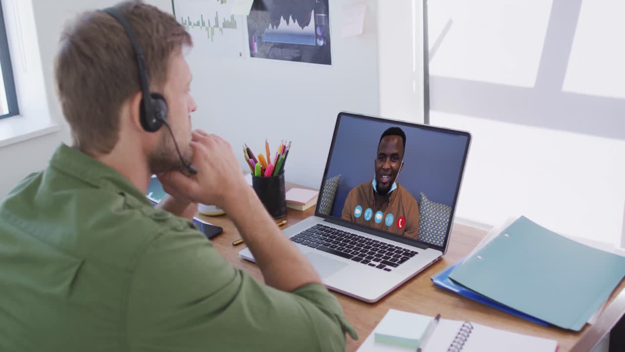 Caucasian man on laptop video chat wearing phone headset at home