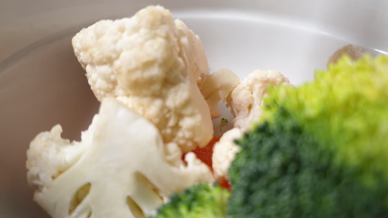 그릇에 떨어지는 끓일 준비가 된 깨끗하고 잘린 야채 모듬