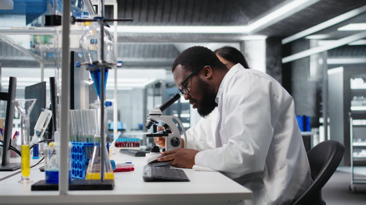 Vertical video Multiethnic nanotechnology researchers using microscope