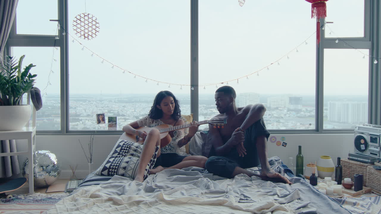 Man Enjoying the Song of Girlfriend Playing the Guitar in Bedroom